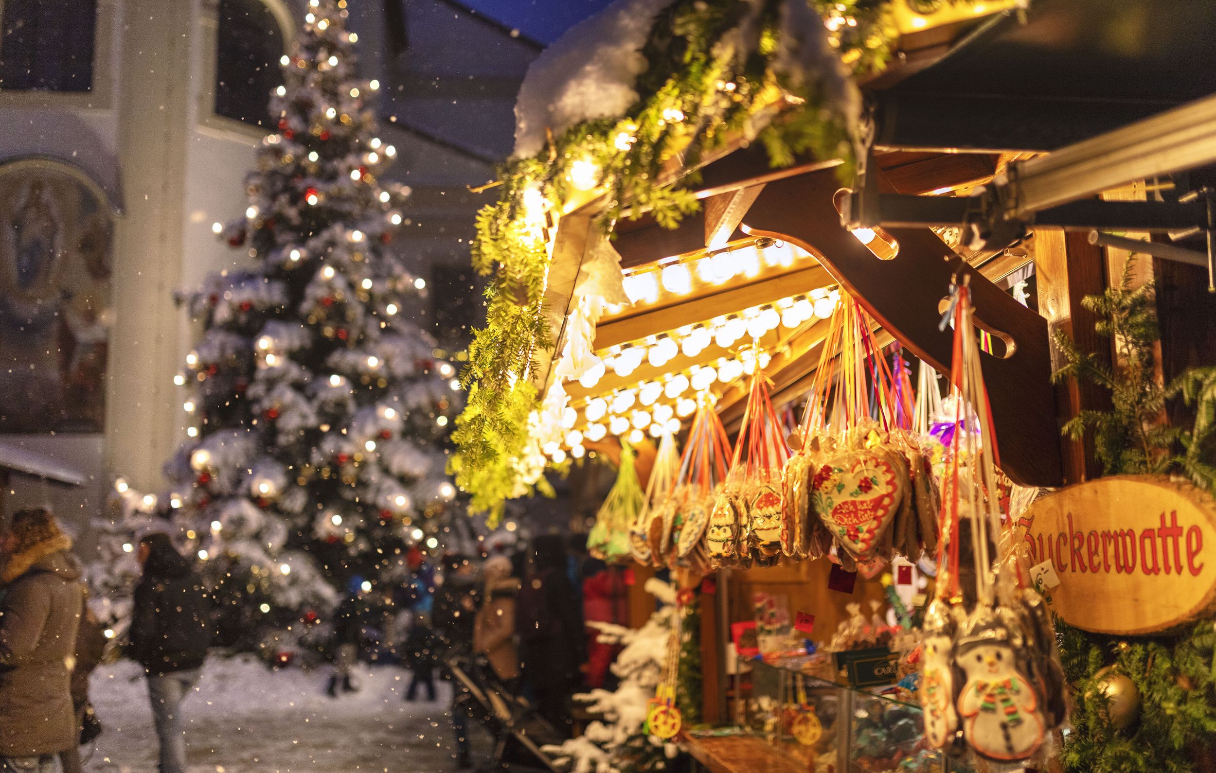 Ein Süßigkeitenstand auf einem verschneiten Weihnachtsmarkt